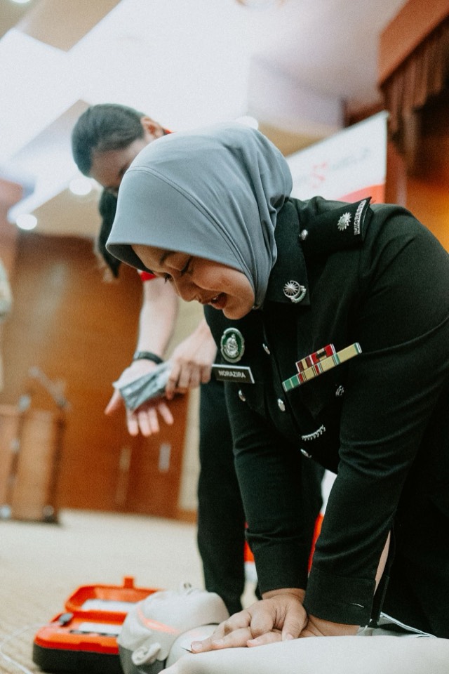 A uniformed officer practising chest compressions